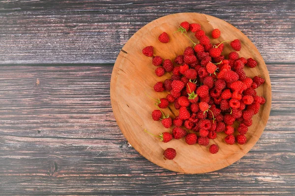 Hallon på en träplatta. Trä rund, platt tallrik. på en träbakgrund. Trä block med orden C-vitamin, färska frukter i bakgrunden, hälsosam mat eller kost koncept. Utsikt ovanifrån. — Stockfoto