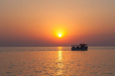 Yat, tekne, ufuktaki tekne ve güzel bir günbatımının silueti, sıcak gün batımı. yolcu gemisi