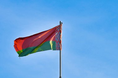 Gökyüzü arka planında Beyaz Rusya bayrağı. Rüzgarda gelişiyor. Beyaz Rusya Bayrağı.
