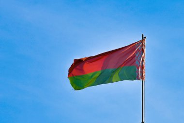 Gökyüzü arka planında Beyaz Rusya bayrağı. Rüzgarda gelişiyor. Beyaz Rusya Bayrağı.