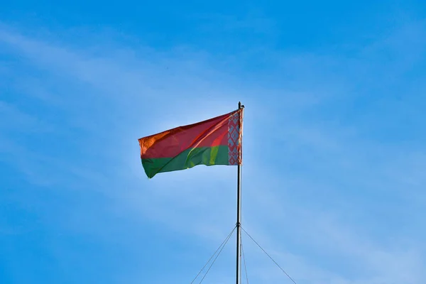 Bandeira bielorrussa no fundo do céu. Desenvolve-se ao vento. Bandeira da Bielorrússia . — Fotografia de Stock