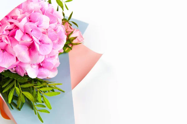 Rosa blomma bukett på en vit bakgrund. i presentförpackning. Plats för inskription. Lätt att skära. Utsikt uppifrån. närbild. — Stockfoto