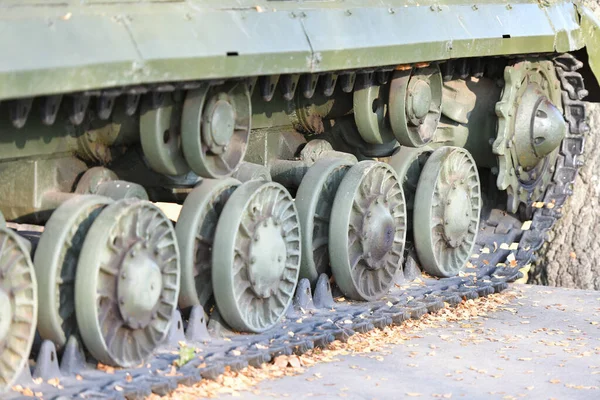 タンクホイールを閉じます。重戦車の鉄軌道。重戦車の鉄の毛虫と車輪。地面に立つタンクの緑の毛虫の正面部分の眺めwi — ストック写真