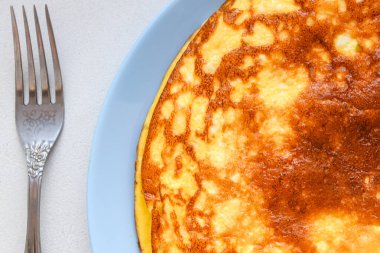 Sebzeli omlet. Mavi tabak. Yukarıdan bak. Kahvaltıda servis edilen sebzeli omlet. Yukarıdan görüntüle