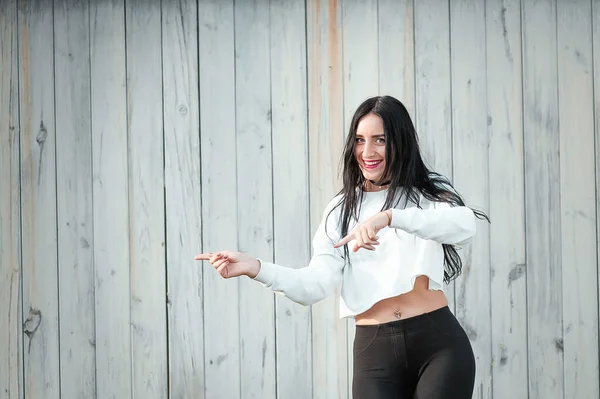 Retrato de uma bela jovem mulher em uma camiseta branca com cabelo preto. alegria e riso degenerado. emoções positivas. Estilo de vida. beleza e juventude. sobre um fundo branco Emoções positivas e alegres — Fotografia de Stock