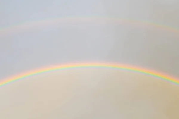 Two rainbows in the sky. Bright rainbows dancing in the light air clouds above and the foggy sky after rain below. natural shot.