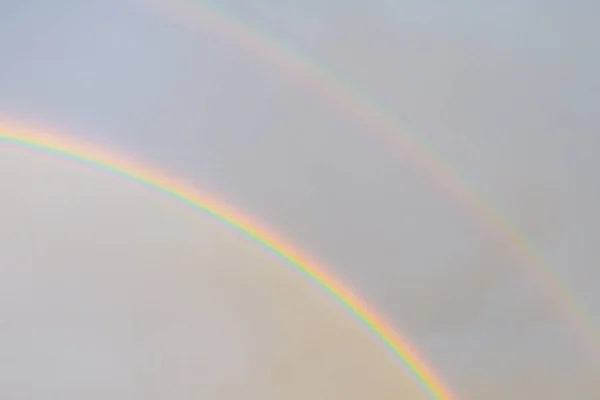 Two rainbows in the sky. Bright rainbows dancing in the light air clouds above and the foggy sky after rain below. natural shot.