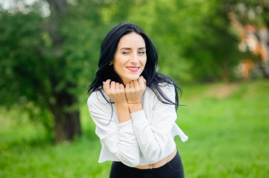 Beyaz tişörtlü, siyah saçlı güzel bir kadının portresi. Neşe ve kahkaha yozlaşmış. pozitif duygular. Yaşam tarzı. güzellik ve gençlik. beyaz bir arka planda pozitif ve neşeli duygular