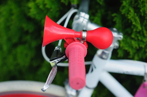 Brzęczyk na rowerze. czerwony w stylu retro. na białym rowerze. koncepcja bezpieczeństwa pieszych i ostrzegania. Czerwony róg, rogi, brzęczyk, sygnał dźwiękowy. — Zdjęcie stockowe