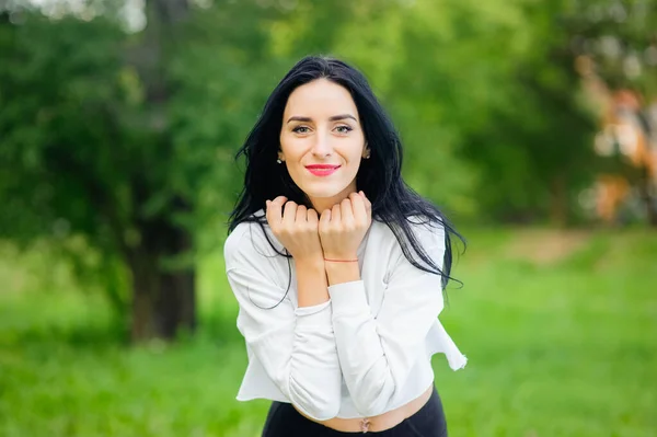 Retrato de una chica alegre en la naturaleza. con pelo negro y capuchas pintadas en una camiseta blanca. emociones naturales. Hermosa chica sonriente con los ojos abiertos . —  Fotos de Stock