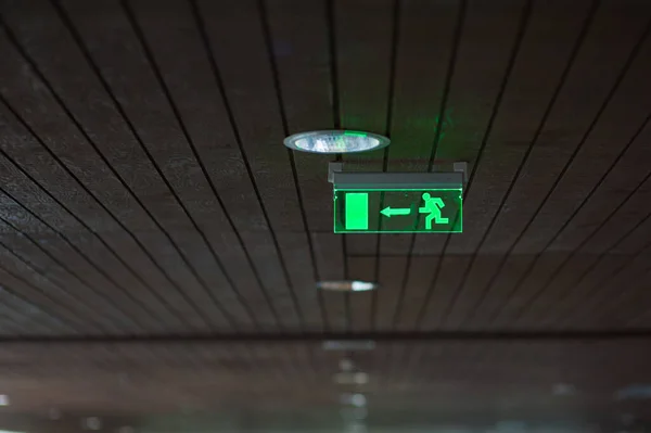 The exit sign of the building glows green — Stock Photo, Image