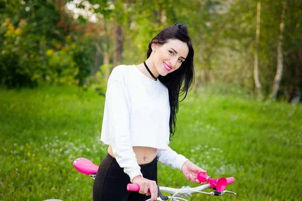 Ragazza sportiva va in bicicletta. emozioni e stile di vita. Giovane bella donna in bicicletta nel parco. Persone attive. Per strada. stile di vita sano — Foto Stock