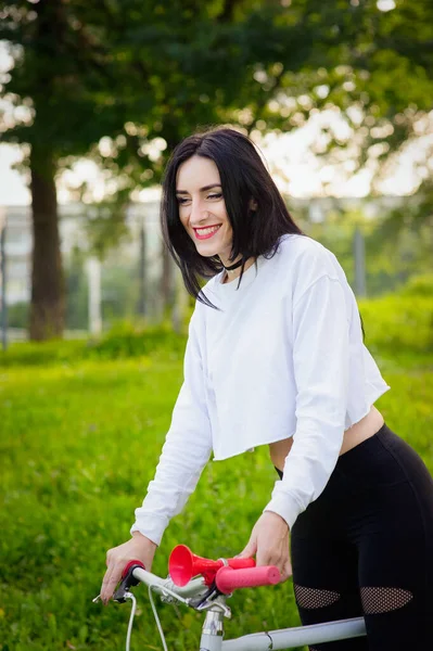 Sportmeisje rijdt op een fiets. emoties en levensstijl. Jonge mooie vrouw op een fiets in het park. Actieve mensen. Op straat. gezonde levensstijl — Stockfoto