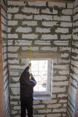 Bir adam kabloları ölçer, doğruluk önemlidir.