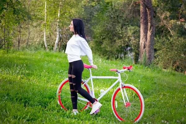 Chica de deportes monta una bicicleta. emociones y estilo de vida. Joven hermosa mujer montando una bicicleta en el parque. Gente activa. En la calle. estilo de vida saludable — Foto de Stock