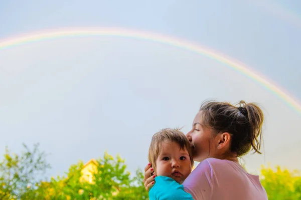 symbolism of love, rainbow sky, love. heart shaped hands and rainbow in the sky. double rainbow.