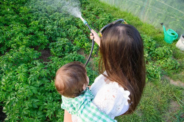Ibu dan anak menyirami rumah. makanan eko. tanpa aditif. makanan sehat untuk bayi . — Stok Foto