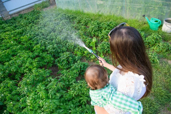Ibu dan anak menyirami rumah. makanan eko. tanpa aditif. makanan sehat untuk bayi . — Stok Foto