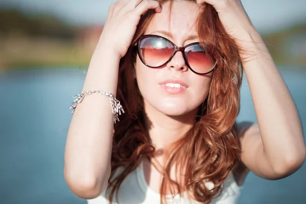 Fille rousse en lunettes de soleil. Gros plan. émotions. Jeune fille rousse se détendre dans les lunettes de soleil. femme se relaxant à l'extérieur. enfoncer les yeux des rayons du soleil . — Photo