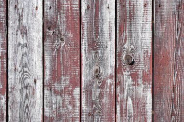 Kırmızı-gri ahşap arka plan. Dikey panolar. Eski boyalar soyulur. Eski tahtalar. Yıpranmış bir tahtanın kırmızı gri ahşap dokusu. Kırmızı, gri ahşap, eski, yıpranmış tahta.