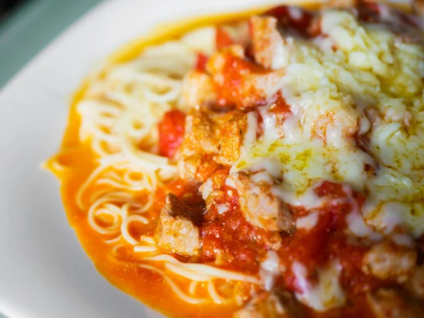 pasta with pieces of chicken and tomatoes on a white plate. Spaghetti with tomato sauce and pieces of chicken or turkey. Italian food. Selective focus