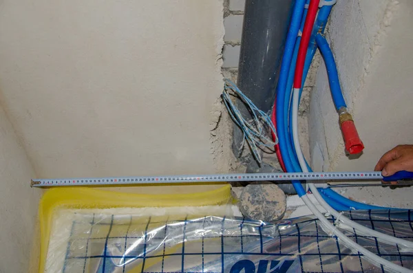 测量塑料管。 更换公寓内铁管的管道工 — 图库照片