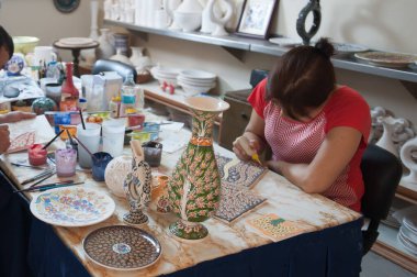 Elle boyanmış tabaklar, kız tahtaya resim çiziyor.