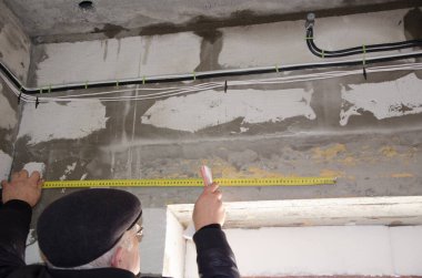 Bir adam kabloları ölçer, doğruluk önemlidir.