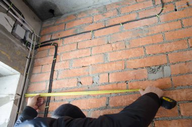 Bir adam kabloları ölçer, doğruluk önemlidir.