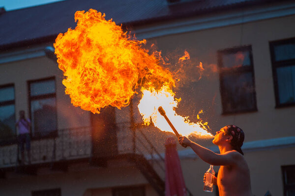 a young man spews a fire out of his mouththe young man spews fire from his mouth. spectacle for visitors