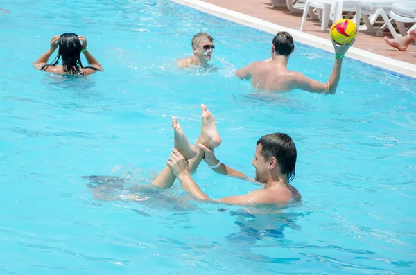 Az emberek a medencében játszanak. Veszélyes játékok nyaralás — Stock Fotó