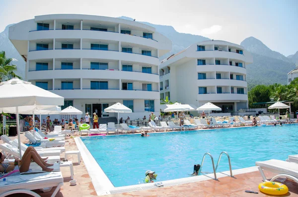 Vacation tourists around the pool in hot weather — Stock Photo, Image