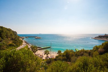 Mavi dalgalar sahilin kayalarına çarpıyor.