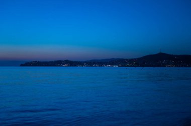 Mavi deniz gün batımında Ada ve ay ile