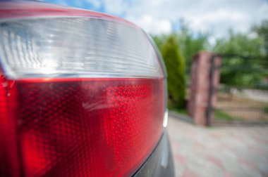 Arka lambalı siyah araba avluya park edilmiş.