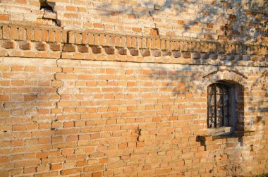 Güneşle aydınlatılan pencereli tuğla duvar