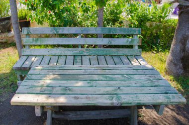 Doğada yeşil banklı ahşap masa.