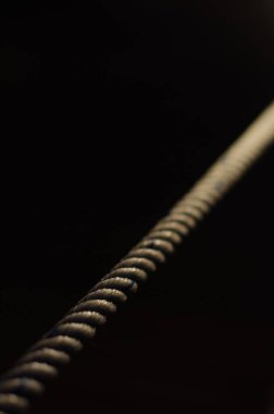 Siyah zemin üzerinde düz bir ip ışıkla aydınlatılır.