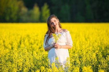 Güzel, hamile, esmer, güzel, hamile bir kadın. Sevgi ve özenle karnına dokunuyor. Kalp şeklinde..
