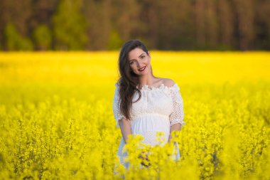 Sahada hamile bir kız var. 7 aylık hamilelik. Annelik kavramı. Renkli fotoğraf.