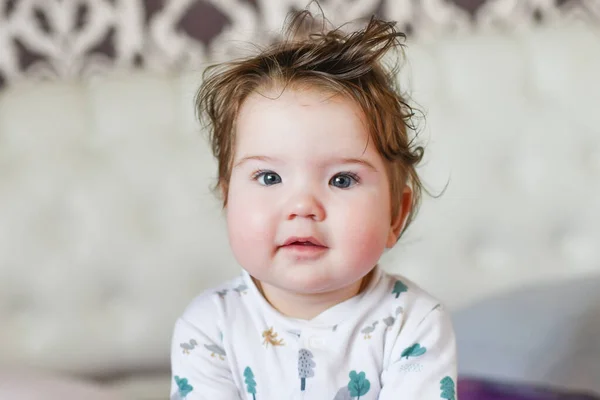 Schattige baby, van dichtbij. Portret van een kruipende baby op het bed in haar kamer — Stockfoto