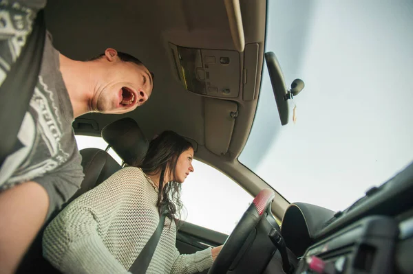 Fear when the girl is driving. The woman calmly drives the car, and the man in the next seat is very frightened. Fully frightened navigator because of the reckless driving of a woman.