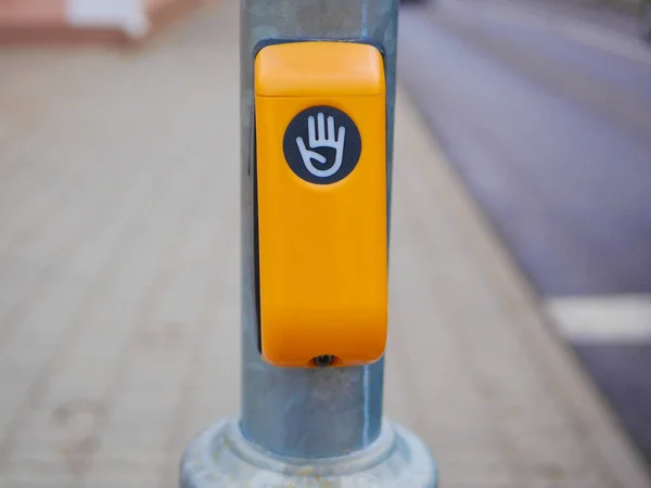 Drücken, um die Straße zu überqueren. Gelber Knopf zum sicheren Überqueren der Straße an einer Eisenstange — Stockfoto