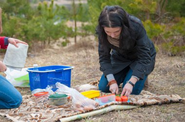 Kız piknikte sebze doğruyor, açık havada yemek pişirirken salata için sebze doğruyor..