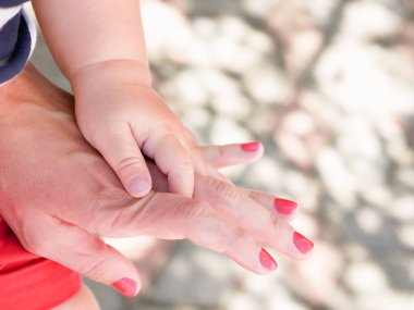 Anne eli bebeğini tutuyor. Yeni doğan çocukların anne eli. Annesi ve çocuğu. Mutlu Aile kavramı. Anneliğin güzel kavramsal görüntüsü 