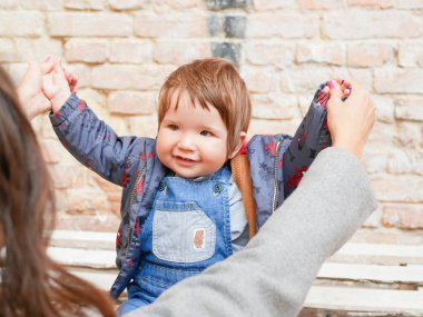 Anne çocuğun elini kaldırır. Mutlu Anne Bebekle Oynuyor.