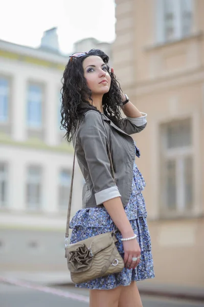 Jeune fille en robe bleue marchant dans la ville. Jeune femme posant dans une robe bleue dans la vieille ville . — Photo
