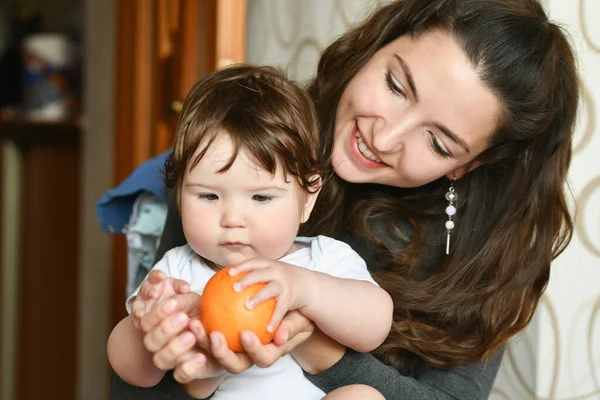 Annem bir çocuğa portakal verir. Çocuğa vitamin verin. Çocuklar için meyve. sağlıklı beslenme — Stok fotoğraf