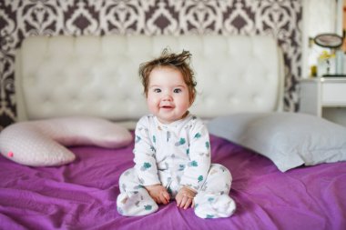 Kestirdikten sonra mutlu bir bebek. Sağlıklı uyku, güçlü bir çocuğun garantisi. Tatlı küçük erkek bebek, banyodan sonra yatakta dinleniyor, mutlu bir şekilde gülümsüyor, gündüz vakti. 