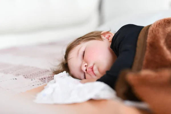 宝宝白天的睡眠。 新生儿的日间健康睡眠。 孩子睡在床上的骨科儿童茧中。 与父母积极游戏后的儿童休息 — 图库照片